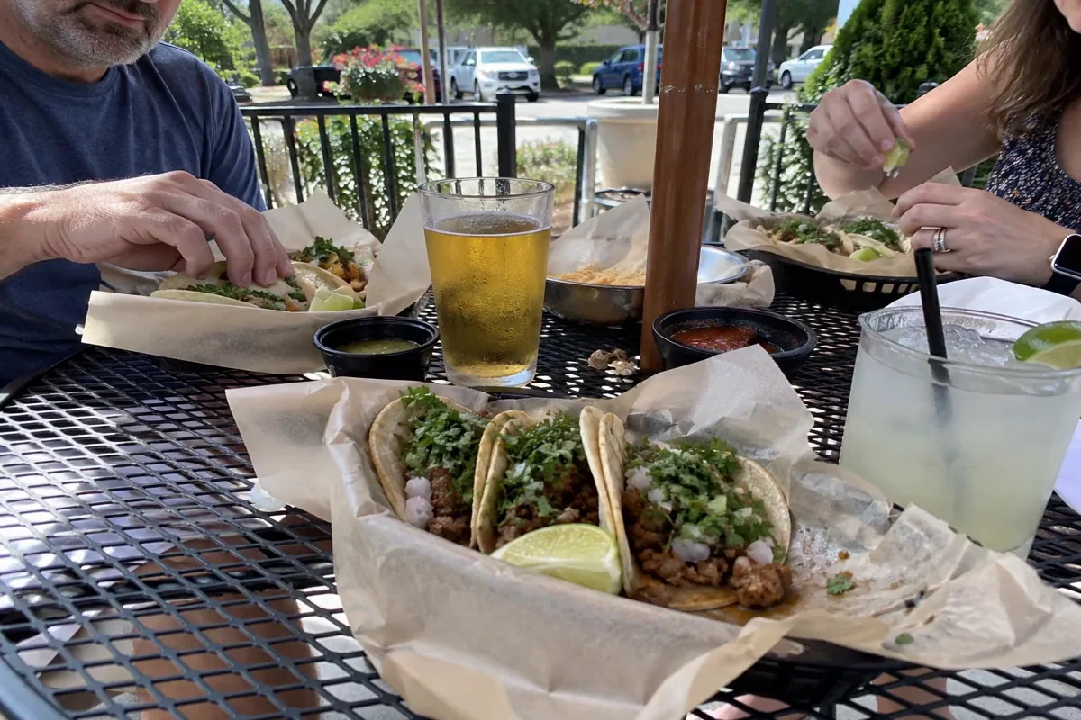 Friends sharing tacos on a sunny patio